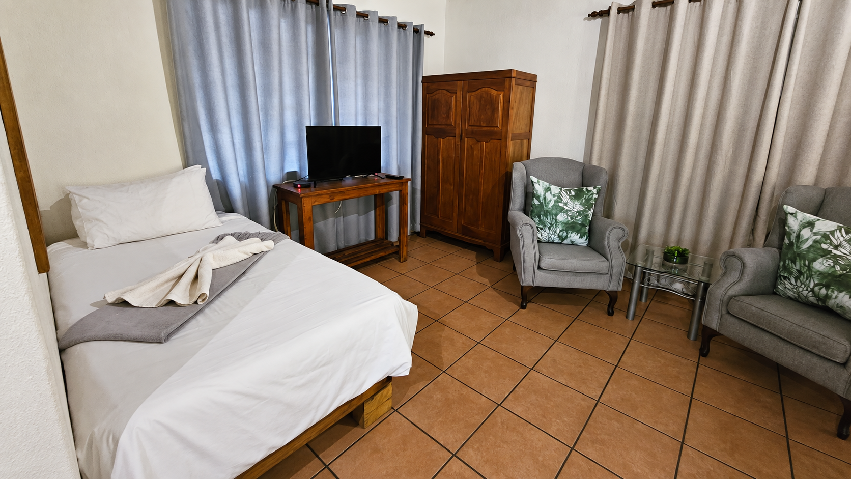 Single bed, television and seating in Baby Lodge