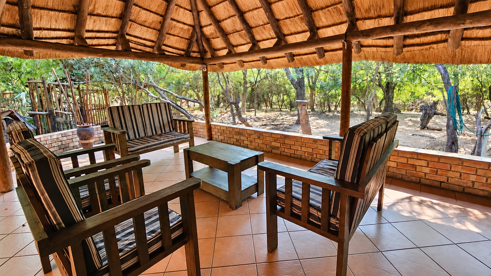 Dining table and chairs beneath the thatch