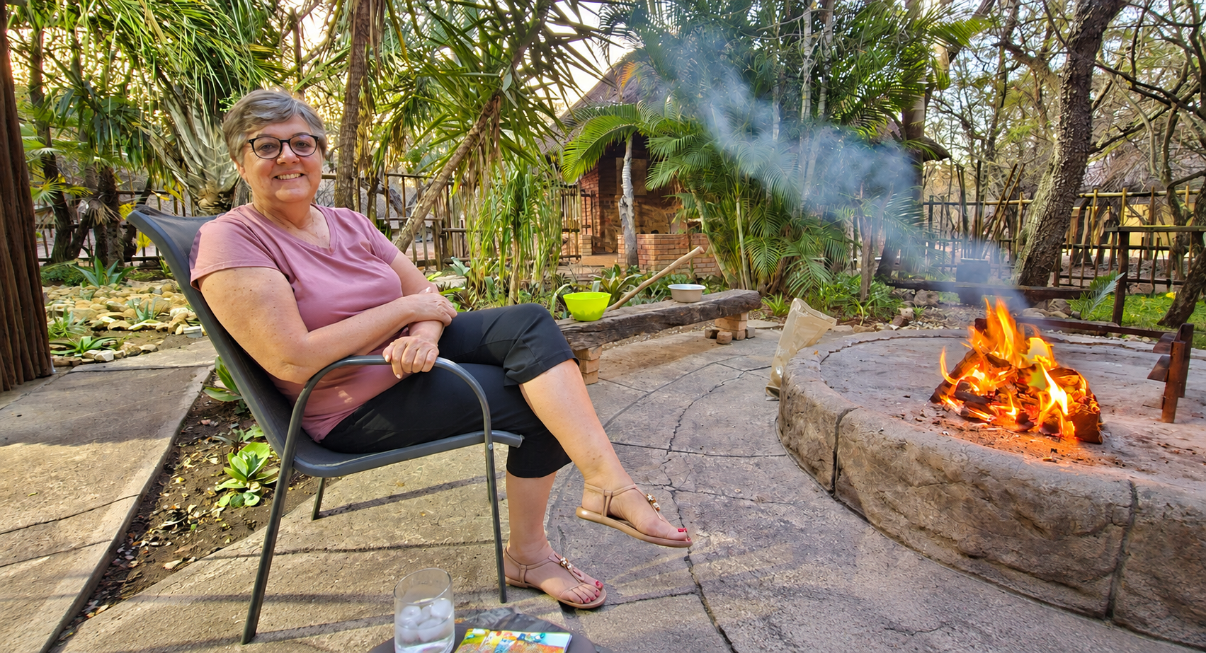A guest seated beside the outdoor campfire